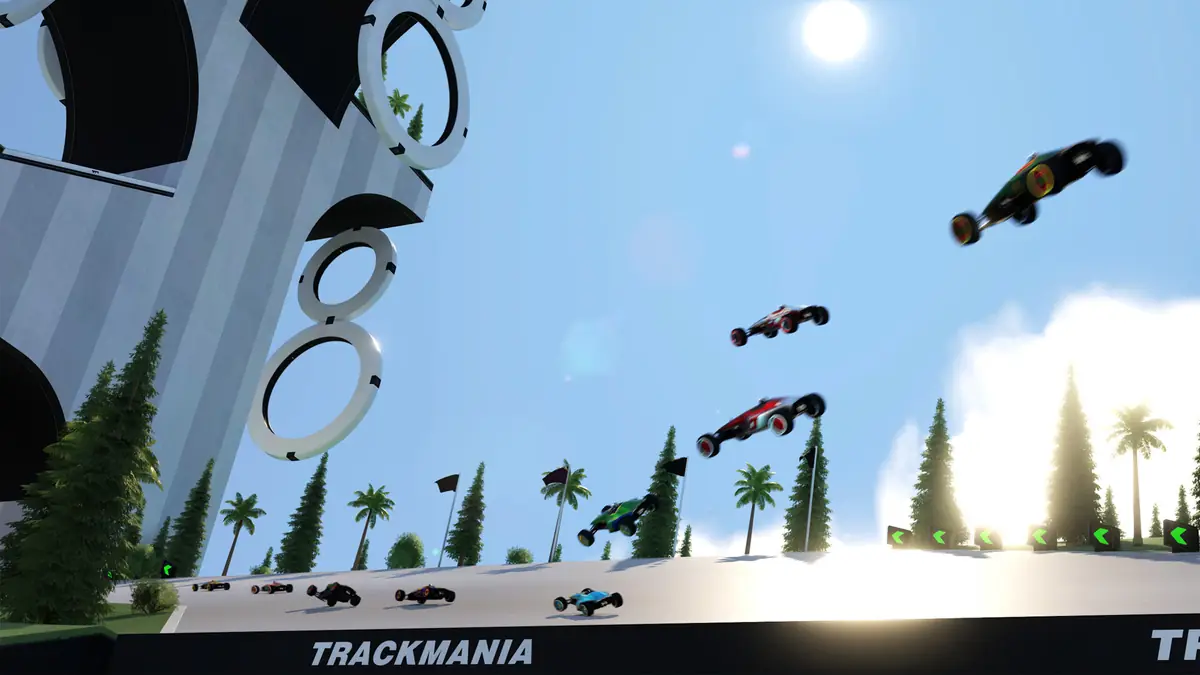 Trackmania: vários carros em pleno voo depois de um salto, junto a uma estrutura com anéis gigantes